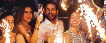 A group of friends standing drinking champagne and laughing