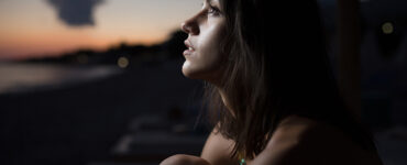 Pensive white woman staring at the twilit sky