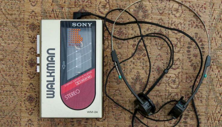 a walkman with wire headphones sitting on a beige rug
