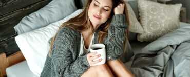 A woman enjoys coffee in bed