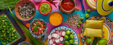 a variety of mexican foods laid out on a colorful table