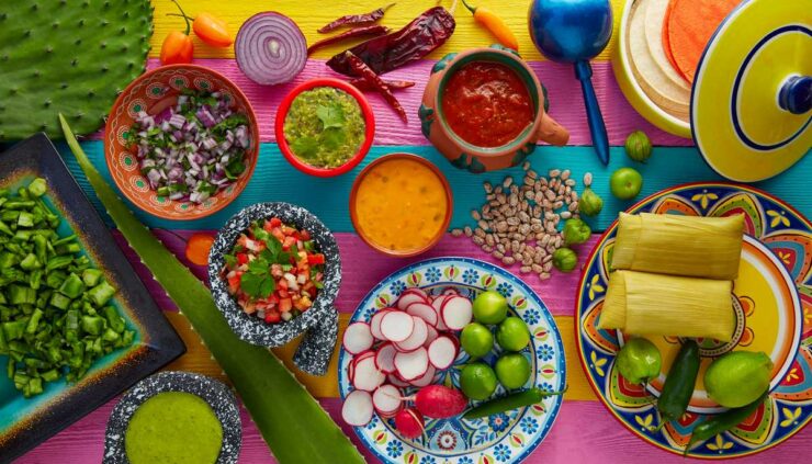 a variety of mexican foods laid out on a colorful table