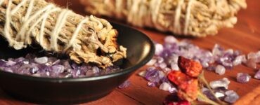 sage bundles on top of stones on a wooden table