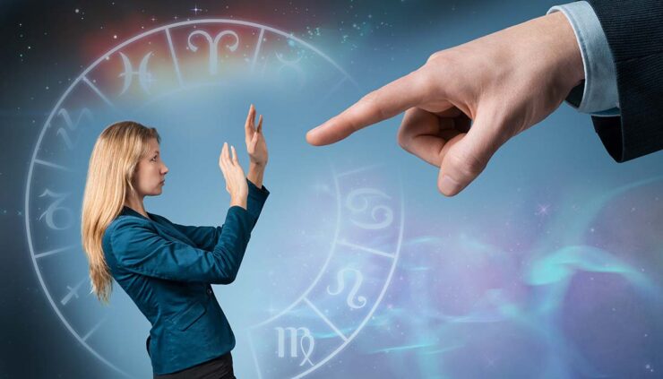 a small woman gets fired by a large hand with zodiac signs in the background