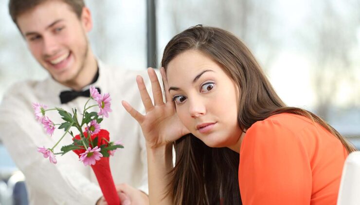 a woman appears disgusted while a guy offers flowers during a blind date