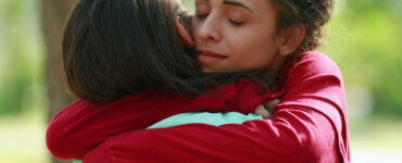 Two women share a consoling hug.