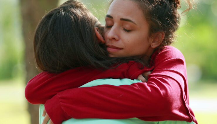 Two women share a consoling hug.