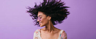 African American woman dances on a purple background.