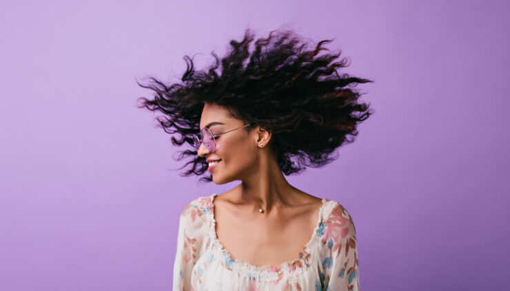 African American woman dances on a purple background.