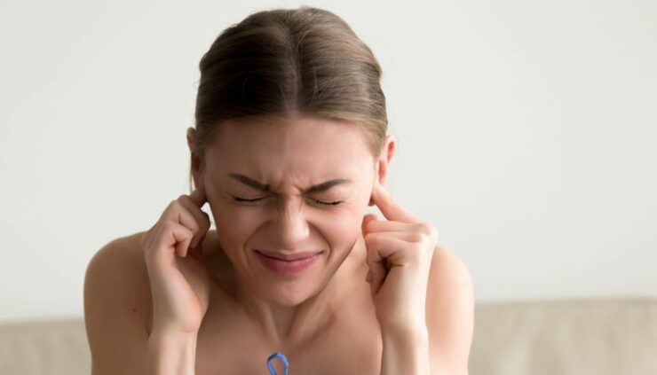 Woman plugging her ears.