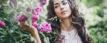 Dark haired woman smelling flowers