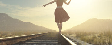 Woman balancing on railroad track