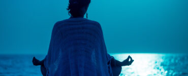 Woman meditating on beach