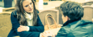 Woman and man hold hands at a cafe