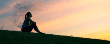 Silhouette of woman looking up at the sky