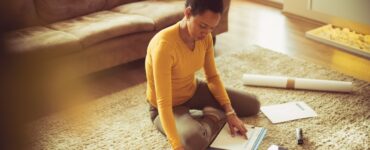 a woman sitting on the floor being productive