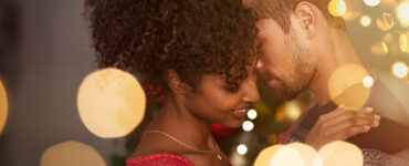 Couple kissing under christmas lights