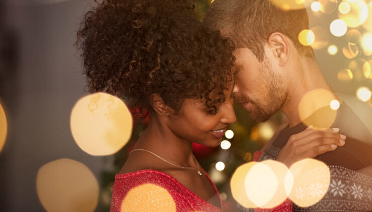 Couple kissing under christmas lights