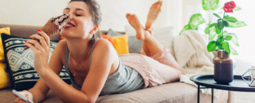 Woman on couch eating ice cream