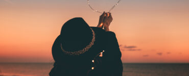 Woman holding heart made of twinkle lights