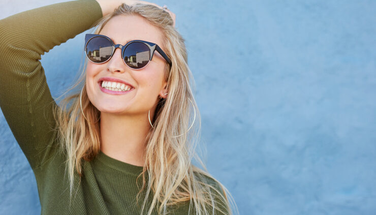blonde-woman-smiles-in-sunglasses-and-green-shirt