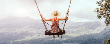 Woman on swing overlooking mountains