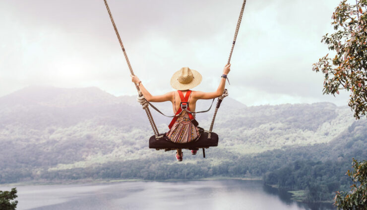 Woman on swing overlooking mountains