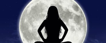 Woman sitting in front of full moon