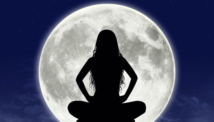 Woman sitting in front of full moon